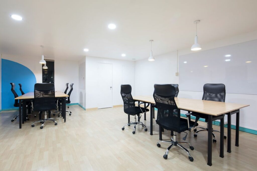 Open-plan office layout with clean-lined solid wood tables and ergonomic seating. Great for co-working environments or flexible desk arrangements.