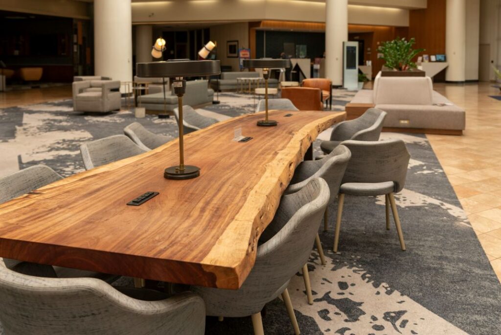 This live edge conference table brings warmth and character into a modern office setting, with its natural wood grain and raw edge design making it a standout piece for collaborative spaces. Surrounded by contemporary chai